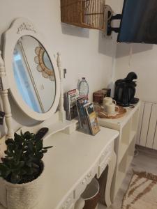 巴苏萨赫Chambre d'hôtes kaxu的白色梳妆台,带镜子和盆栽植物