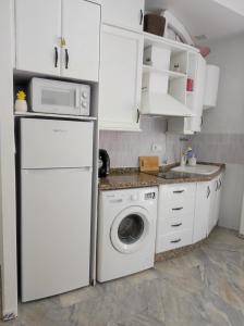 奇皮奥纳Apartamentos home Chipiona的厨房配有洗衣机和微波炉。