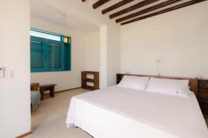 Tintipan IslandCasa Tinti Hotel Boutique的卧室配有白色的床和窗户。