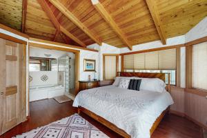 IslandaleHorizon's End的一间带一张床的卧室,位于带木制天花板的房间内