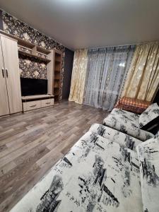 巴甫洛达尔Назарбаева 204的一间带床和电视的客厅