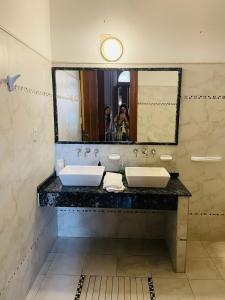 胡宁Casa Viva Hotel Boutique的画着带两个盥洗盆的浴室的人