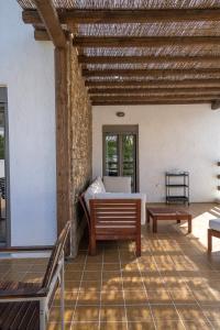 卡利诺岛Apollonas & Sibylla Villa的客房设有一张床,庭院设有长凳