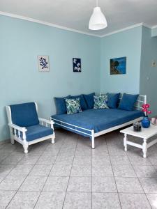 圣帕拉斯凯维Zoel's House in Chalkidiki的客厅配有蓝色的沙发和椅子