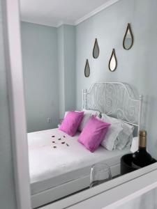 圣帕拉斯凯维Zoel's House in Chalkidiki的卧室配有白色床和粉红色枕头