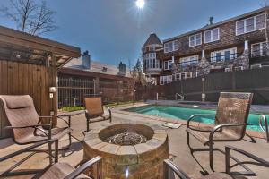 帕克城Luxury Condo Steps to Park City Mountain Resort! Heated Pool & Hot Tub -Snowblaze 309的一个带椅子和火坑的庭院,毗邻一个游泳池