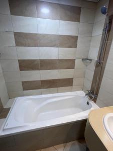 迪拜Dubai Entire Serviced Room Unit Excellence的浴室配有白色浴缸及水槽
