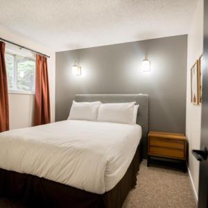 贾斯珀跨海山旅舍的卧室配有一张带白色床单和枕头的大床。