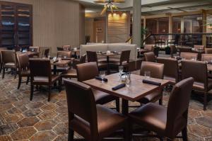 欧弗兰帕克DoubleTree by Hilton Kansas City - Overland Park的用餐室配有木桌和椅子