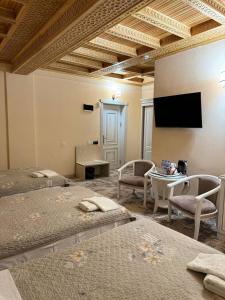 撒马尔罕阿尔巴酒店的客房设有两张床和一台平面电视。