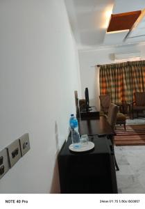 伊斯兰堡Palladium Executive的一间桌子上装有一瓶水的房间