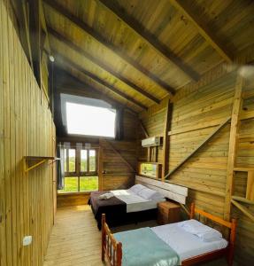 普腊亚罗萨Pousada Vale da Magia的小木屋内带两张床的房间