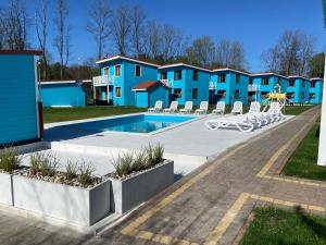 里沃Domki przy plaży Owocowy Ogród的一个带游泳池和蓝色公寓的度假胜地