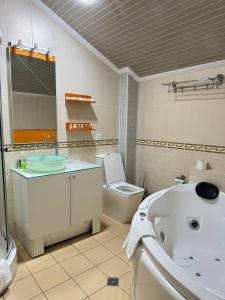 撒马尔罕阿尔巴酒店的带浴缸、卫生间和盥洗盆的浴室