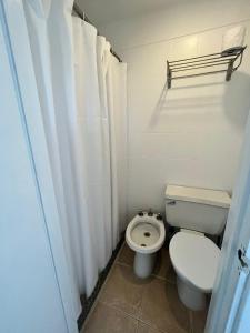 埃斯特角城ZAG Coliving Punta del este的一间带卫生间和浴帘的小浴室