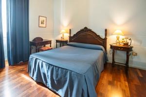 列雷纳丽瑞纳霍斯德麦瑞达酒店的一间卧室配有一张床、两张桌子和两盏灯。