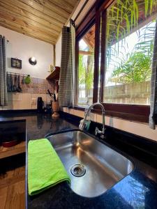 特林达德Hospedagem Casa Maracujá的厨房水槽和柜台上的绿毛巾