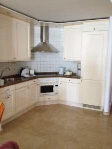大加那利岛拉斯帕尔马斯Anfi Beach Club 29 Jul a 04 Ago的厨房配有白色橱柜和炉灶烤箱。