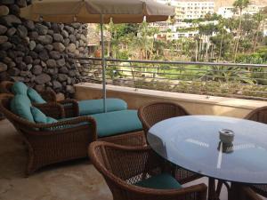 大加那利岛拉斯帕尔马斯Anfi Beach Club 29 Jul a 04 Ago的庭院配有桌椅和遮阳伞。