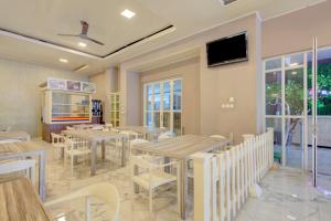 雅加达Super OYO 4005 Bunga Dahlia Guest House的餐厅设有桌椅和平面电视。