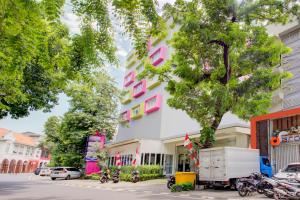 雅加达Super OYO 4005 Bunga Dahlia Guest House的城市街道上的粉红色和白色建筑