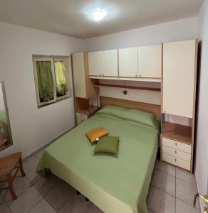 维耶斯泰Villa Angela case vacanza的一间小卧室,配有一张绿色的床和白色的橱柜