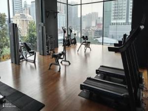 吉隆坡Anggun Residence Kuala Lumpur的健身房设有数种健身器材和大窗户