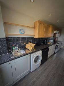 诺丁汉Chippenham Place, 3 Bedroom House, NG5的厨房配有水槽和洗衣机