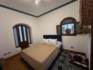 Al Mazghūnahpyramids view Guest villa的一间卧室设有一张床和两个窗户。