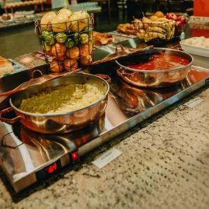 伊比乌纳Paraty Hotel Fazenda & Spa的自助餐,在柜台上供应三碗食物