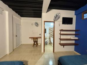 莱蒂西亚Cruz Roja - Turismo Solimões的一间设有蓝色墙壁和一张桌子的卧室和一间房间