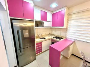 约恩维利Apartamento inteiro muito aconchegante的厨房配有紫色橱柜和粉红色的柜台