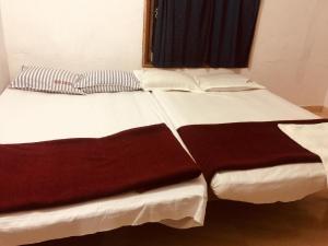 耶拉吉里Woodside Resort and Cafe的一张白色的大床,配有棕色和白色的床单