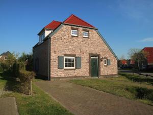 罗赫尔Comfy farmhouse villa in Limburg的红屋顶砖屋和车道