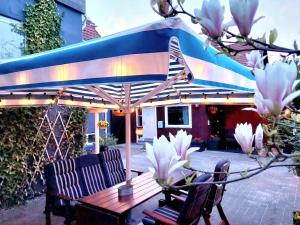 哥本哈根Guesthouse 'Blue House' in vintage villa&garden的蓝色伞下的一张木桌和椅子