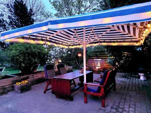 哥本哈根Guesthouse 'Blue House' in vintage villa&garden的木制凉棚下配有桌椅