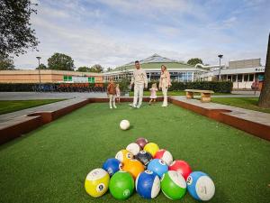 罗赫尔Tidy, child-friendly villa with a sauna in Limburg的两个成年人和两个孩子站在一排球旁边