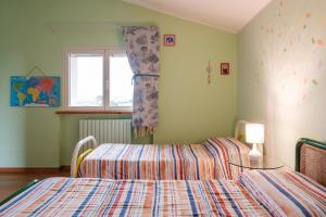 奥西莫La Gipsofila Attic的一间卧室设有两张床和窗户。
