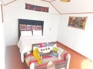 普诺Coila Titicaca lodge的一间卧室配有一张床和两把椅子
