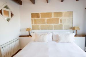 马翁尤可马桑尼斯大农场酒店的卧室配有白色的床铺和白色的枕头
