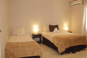 佩诺诺梅Brisas de Coclé的酒店客房设有两张床和两盏灯。