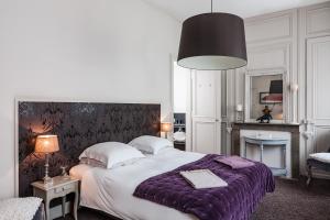 里尔香普兰旅馆 - 住宿加早餐旅馆的一间卧室配有一张大床和紫色毯子