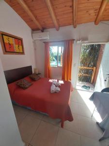 米娜克拉韦罗Complejo Cantonavi的卧室配有红色的床,里面装有两只动物