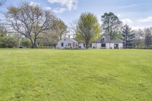 盖尔斯堡Knoxville Area Getaway on 22 Acres with Pond Access!的一座大型白色房子,设有大片草地