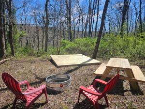 洛根Sycamore Ridge Campsite at Hocking Vacations - Tent Not Included的两张椅子、一张野餐桌和一个火坑