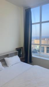 阿吉曼P3) Fantastic Seaview Room with shared bath inside 3bedroom apartment的一间卧室设有一张床和一个大窗户