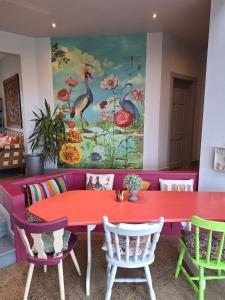 朗德伍德Lus Mor的红色的桌子和椅子,墙上有绘画作品