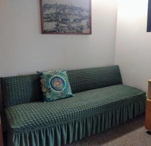 兹诺伊莫Pension Archa的一张绿色沙发,上面有枕头,放在一个房间里