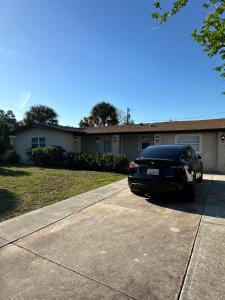 萨拉索塔Private rooms in Spacious Siesta Key home - Huge Backyard的停在房子前面的一辆黑色汽车