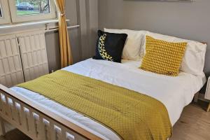 爱丁堡Spacious 3 bed with free parking的一张黄色和白色枕头的床